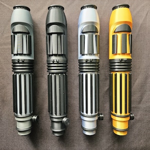 May include: Four cylindrical handles arranged vertically, each featuring a ribbed grip section, a smooth upper body with raised rectangular accents, and a small circular knob near the base. The handles are coloured light grey, black, silver, and yellow.