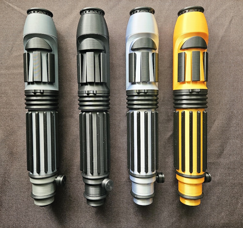 May include: Four cylindrical handles arranged vertically, each featuring a ribbed grip section, a smooth upper body with raised rectangular accents, and a small circular knob near the base. The handles are coloured light grey, black, silver, and yellow.