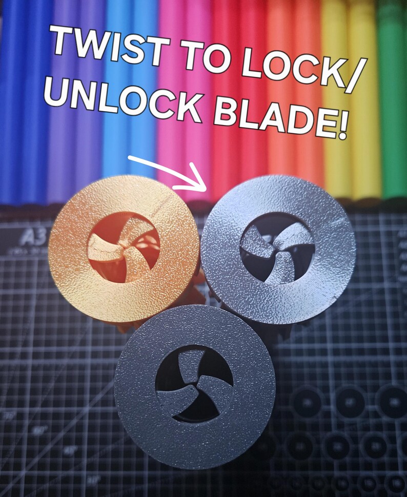 Pu&ograve; includere: Tre oggetti circolari metallici con un design a forma di ventaglio in oro, argento e grigio scuro. Il testo "TWIST TO LOCK/ UNLOCK BLADE!" &egrave; sopra gli oggetti, con una freccia che li indica. Lo sfondo &egrave; una colorata serie di pennarelli.