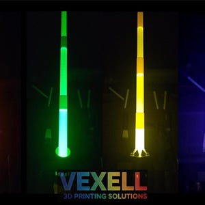 May include: Four vertical, glowing, collapsible light sabres in orange, green, yellow, and purple against a black background. The text VEXELL 3D PRINTING SOLUTIONS is printed in white and multi-coloured letters at the bottom centre of the image.