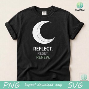 May include: Black t-shirt featuring a white crescent moon design with geometric details. Below the moon, the words "REFLECT. RESET. RENEW." are printed in a mix of black and green. The shirt is a Comfort Colors brand.