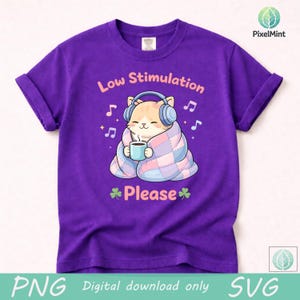 May include: A purple t-shirt with a cartoon cat wearing headphones and wrapped in a blanket, holding a mug. The text "Low Stimulation Please" is above and below the cat, with musical notes scattered around.