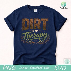 Puede incluir: Camiseta azul marino con mangas enrolladas. La camiseta presenta el texto "DIRT is my Therapy" en un dise&ntilde;o texturizado y desgastado. La palabra "DIRT" es marr&oacute;n, y "Therapy" es verde, con un dise&ntilde;o de planta.