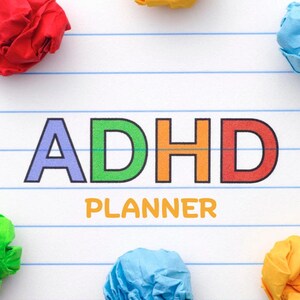 Op de afbeelding: Een witte pagina uit een notitieboek met blauwe lijnen toont de tekst "ADHD PLANNER" in kleurrijke blokletters. Gekreukelde papieren ballen in rood, geel, groen en blauw zijn verspreid rond de tekst, wat een levendig ontwerp creëert.