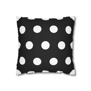 Pode incluir: Almofada quadrada com fundo preto e grandes bolinhas brancas. O design é simples e clássico, adequado para vários estilos de decoração. O padrão de bolinhas é uniformemente espaçado na superfície.