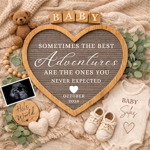 Può includere: Un tabellone a forma di cuore con la scritta "Sometimes the best Adventures are the ones you never expected" e "October 2026". Include un body per neonati, scarpe, un orsacchiotto e un'immagine ecografica. La parola "BABY" è scritta in blocchi di legno.