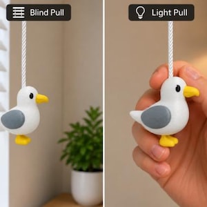 May include: A white and grey seagull-shaped pull attached to a white cord. The image shows two applications: one labelled Blind Pull for window blinds and one labelled Light Pull for a light fixture, featuring a yellow beak and feet.