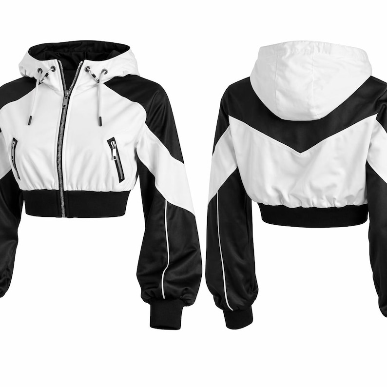 May include: Cropped white and black jacket with a hood. The jacket features a white front and a black back and sleeves. It has a zipper closure and two front pockets. The jacket's design includes white stripes and black cuffs.