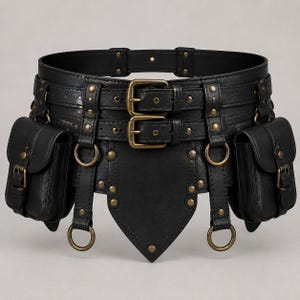 May include: A black utility belt featuring two attached side pouches with buckle closures, a wide waistband with two front brass-toned buckles, multiple brass-toned metal rivets, hanging O-rings, and a pointed centre panel detail.