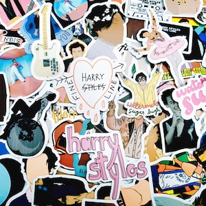May include: A collection of assorted vinyl stickers featuring illustrations of Harry Styles, including a white electric guitar, a heart with the text Harry Styles Fine Line, a person in a pink tutu, and pink text reading Harry Styles.