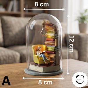May include: A decorative glass dome display featuring a miniature figure reading a book in a yellow armchair, set atop a large book base with a stack of books and a hanging lightbulb. The display measures 8 inches wide and 12 inches tall.