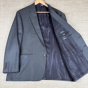 May include: A charcoal gray blazer with a subtle windowpane check pattern, featuring a dark navy blue interior lining, two front buttons, and four buttons on each sleeve cuff. The interior label displays the text Ralph Lauren and Dillard's.