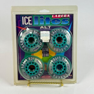 May include: A set of four Labeda Ice Lites inline skate wheels in teal and clear, packaged in a plastic blister pack. The wheels feature a checkered pattern, the text Ice Lites, and Labeda Trick Core branding. A price tag is visible on the front.