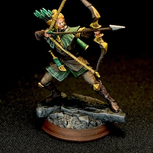 May include: A painted miniature figurine of an archer in a dynamic combat pose. The figure wears green and brown armor, carries a quiver of green-fletched arrows on the back, and holds a large bow with a drawn arrow. It stands on a rocky base.
