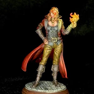 Puede incluir: Figura en miniatura de un personaje femenino con atuendo de fantasía. Lleva un abrigo rojo, un corsé gris y pantalones color caqui. Su mano derecha sostiene una llama brillante. La figura está sobre una plataforma de madera.