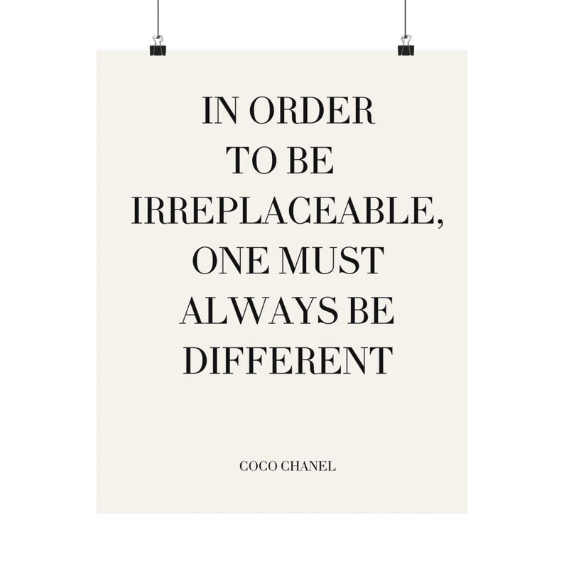 Puede incluir: Un p&oacute;ster crema con la cita "IN ORDER TO BE IRREPLACEABLE, ONE MUST ALWAYS BE DIFFERENT" en texto negro. La cita se atribuye a Coco Chanel.