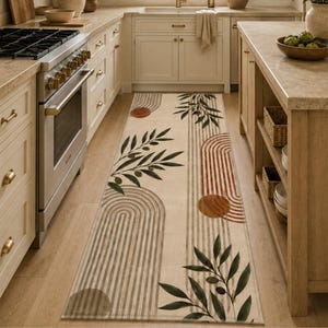 May include: A long rectangular kitchen runner rug featuring a cream background with a repeating pattern of dark green olive branches, terracotta-colored arched lines, and solid circular shapes in shades of brown and orange arranged in a linear design.