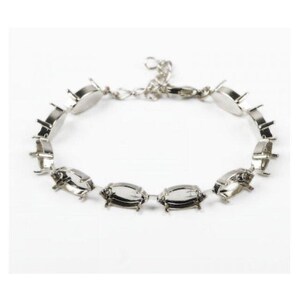 May include: A silver-toned metal bracelet featuring a series of empty oval-shaped settings with small prongs designed for holding stones. The bracelet includes a delicate chain link section with a lobster claw clasp for secure closure.