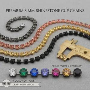 Puede incluir: Cadenas de diamantes de imitación premium de 8 mm en varios colores, incluidos negro, oro rosa, oro y plata. Un calibrador de metal dorado mide un diamante. Debajo, siete diamantes redondos individuales se muestran en blanco, verde, azul, morado, rosa, amarillo y negro.
