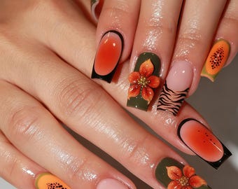 May include: Square-shaped nails featuring a mix of designs including orange jelly-style tips with black outlines, olive green bases with raised 3D orange floral accents, nude bases with black tiger stripes, and orange fruit-inspired patterns.