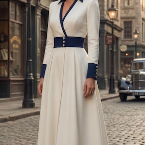 Pode incluir: Um vestido creme em estilo vintage com mangas compridas, gola azul marinho e cinto a condizer. O vestido apresenta punhos azul marinho com botões dourados e é combinado com saltos azul marinho. O cenário é uma rua de calçada.