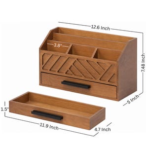 May include: A brown wooden desk organizer with a geometric cutout pattern, featuring a main unit with three top compartments and one drawer, plus a separate matching tray. Dimensions are 12.6 inches wide, 7.48 inches high, 5 inches deep, and 1.5 by 11.9 inches.