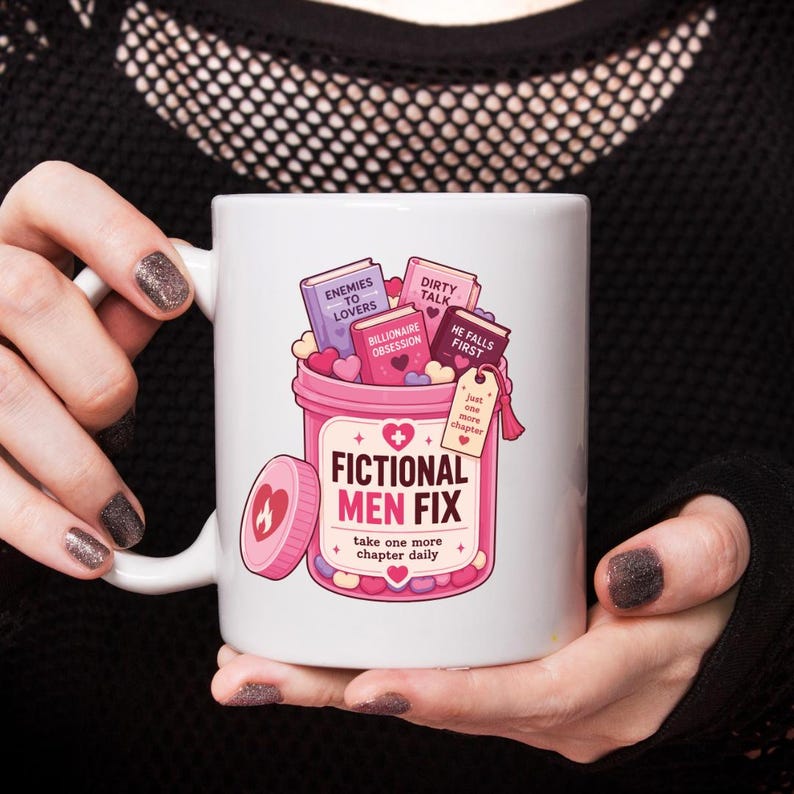 May include: A white ceramic mug featuring a graphic of a pink pill bottle filled with small books and hearts. The bottle is labeled FICTIONAL MEN FIX, take one more chapter daily, with book titles including Enemies to Lovers and Billionaire Obsession.
