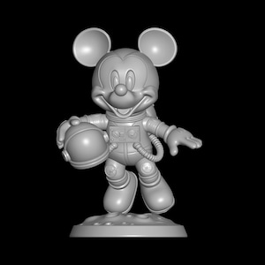 May include: A gray 3D-printed figurine of Mickey Mouse in an astronaut suit, holding a helmet. The figure stands on a lunar surface base, with a black background. The astronaut suit has detailed panels and a hose.