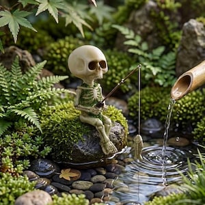May include: A small skeleton figurine sits on a mossy rock, holding a fishing rod with a fish-shaped lure dangling above a stream. A bamboo water feature pours water into the stream, surrounded by green ferns, moss, and smooth river stones.