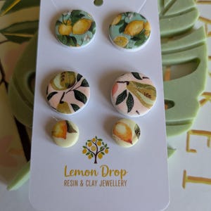 Juego de 3 pendientes de botón, colores complementarios verde y naranja.