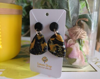 Pendientes colgantes redondos de dos piezas en negro, blanco y dorado. Arcilla polimérica ligera. Hechos a mano con lámina de oro en la arcilla.
