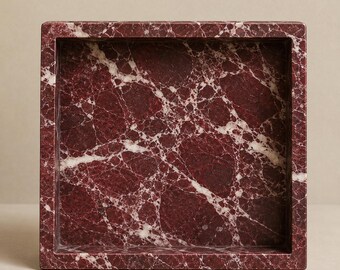 May include: A square tray crafted from deep burgundy red marble featuring prominent white veining throughout the surface. The tray has thick, straight edges and a smooth, polished finish, creating a solid, box-like structure with a recessed center.