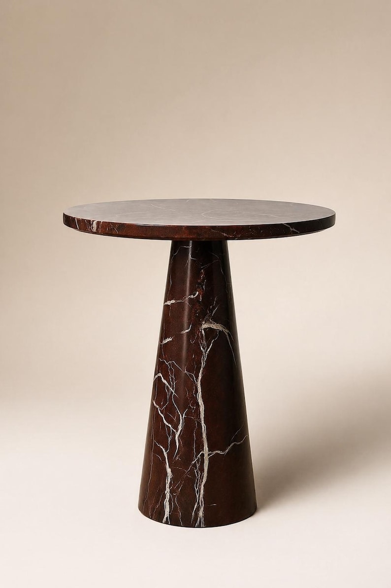May include: A round-top side table with a dark red marble finish and white veining. The table has a conical base and is approximately 24 inches tall.