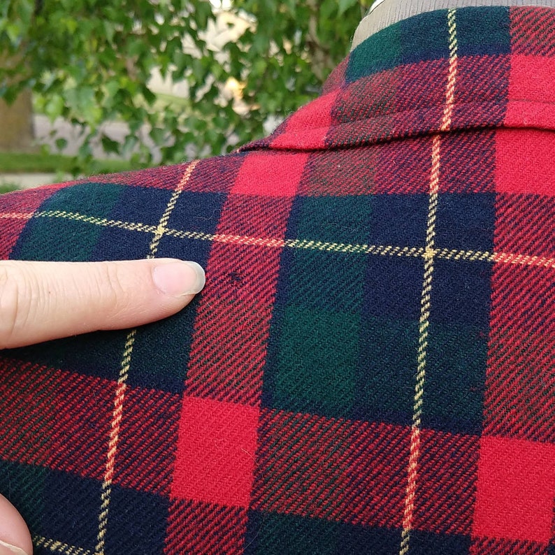 May include: Red, green, and black plaid flannel shirt with a yellow stripe. The shirt is made of a soft, comfortable fabric.