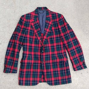 May include: A red, green, and white plaid blazer with a single button closure.