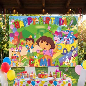 May include: A rectangular birthday party backdrop featuring Dora the Explorer and Diego characters in a colorful park setting. The banner displays the text HAPPY BIRTHDAY and the name CAMILA in large, multi-colored letters with cartoon graphics.