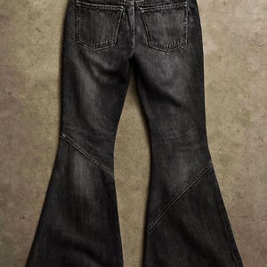May include: Dark gray denim jeans with a flared leg design. The jeans have two back pockets and a classic five-pocket style. The fabric appears to be a medium weight denim.