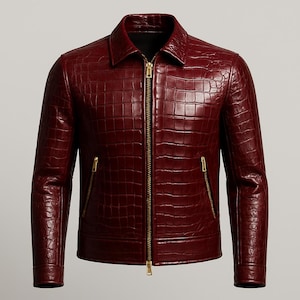 Könnte beinhalten: Burgunderfarbene Lederjacke mit Krokodilleder-Textur. Die Jacke hat einen Kragen, einen durchgehenden Reißverschluss und zwei Reißverschlusstaschen. Die Ärmel sind lang und das Design ist tailliert.