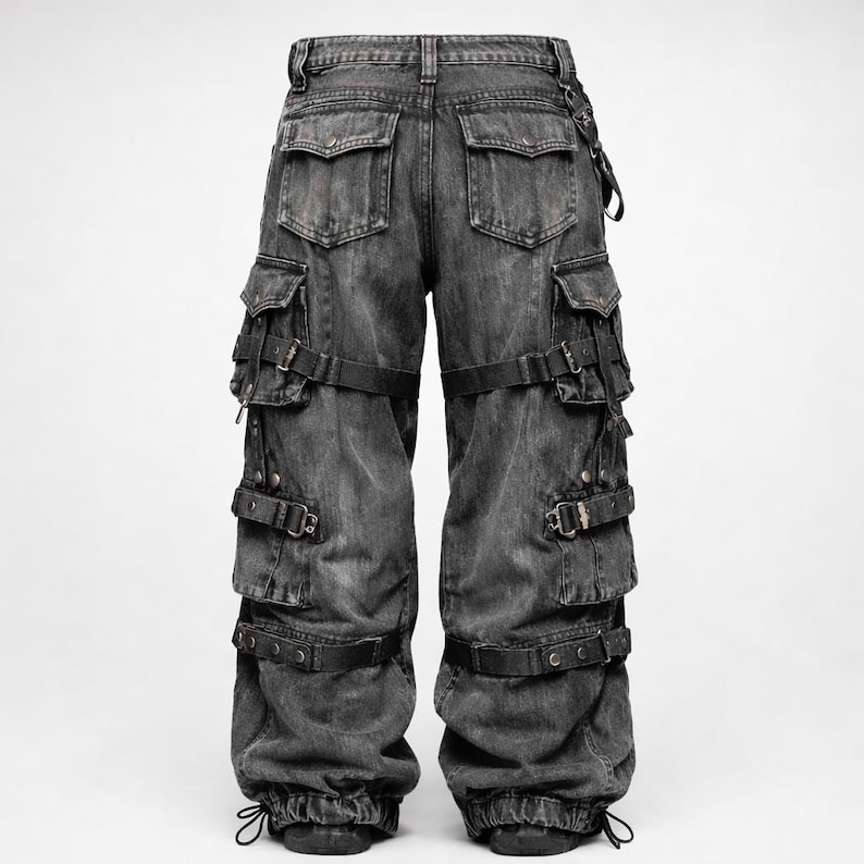 Puede incluir: Pantalones cargo de mezclilla negra descolorida con m&uacute;ltiples bolsillos y correas ajustables. Los pantalones tienen un ajuste relajado y cuentan con un cord&oacute;n en los tobillos. El dise&ntilde;o incluye hebillas y remaches met&aacute;licos.