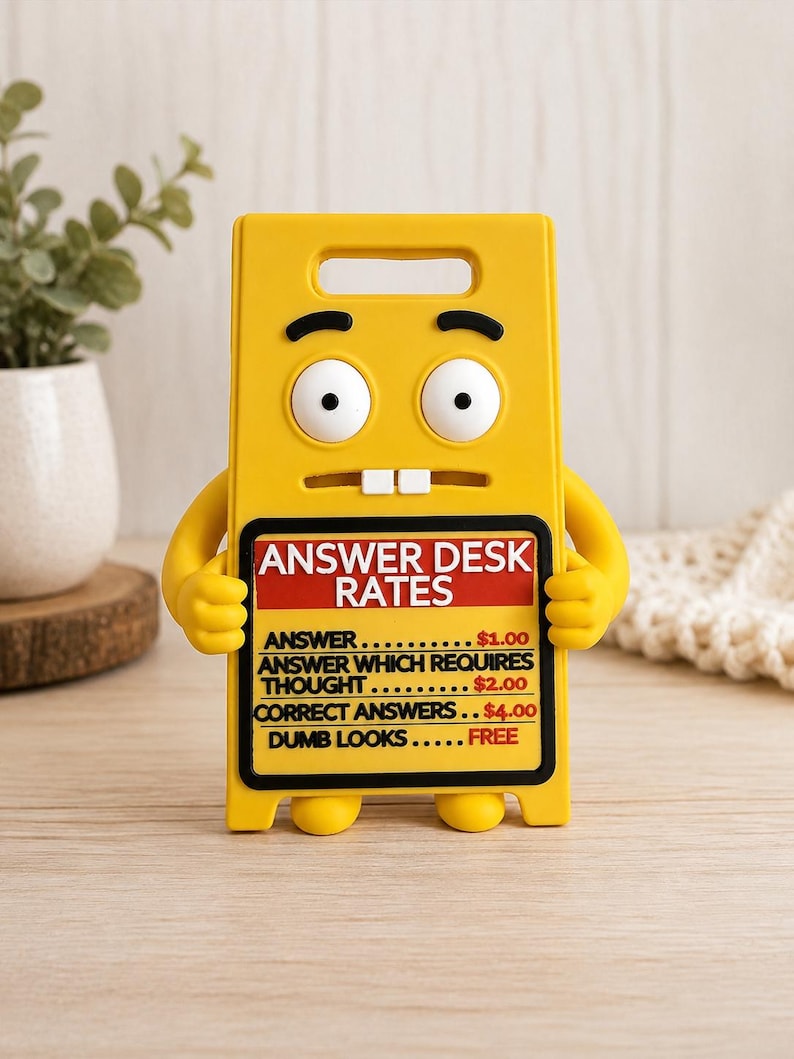 May include: A yellow plastic sign shaped like a cartoon character with wide eyes and two teeth. The sign features the text: ANSWER DESK RATES, ANSWER $1.00, ANSWER WHICH REQUIRES THOUGHT $2.00, CORRECT ANSWERS $4.00, DUMB LOOKS FREE, with a black border.