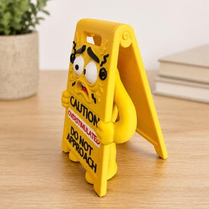 May include: A yellow A-frame caution sign figure with a distressed facial expression, featuring black text that reads CAUTION, OVERSTIMULATED, and DO NOT APPROACH. The figure has wide eyes, a small mouth, and arms holding the sign frame.