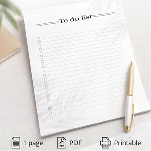 Può includere: Un blocco note bianco "To do list" con pagine a righe e caselle di controllo. Le parole "To do list" sono stampate in alto. Una penna oro e bianca poggia sul blocco note. Il blocco note è un PDF stampabile.