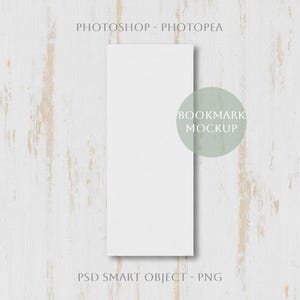 Puede incluir: Maqueta vertical de marcapáginas blanco sobre un fondo de vetas de madera clara. El texto "BOOKMARK MOCKUP" está en un círculo verde. También son visibles los textos "PHOTOSHOP - PHOTOPAE" y "PSD SMART OBJECT - PNG".