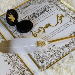 May include: A wedding certificate with gold accents, a decorative feather pen, and a black ink pad. The certificate has ornate floral borders and gold lettering. The pen has a white feather and gold details.