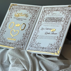 May include: An open, white wedding certificate with gold accents and floral borders. The left page has gold numbers, hearts, and the date 07/02/2026. The right page has Arabic script and the names Luis Cabrera and Rinki Ansari.