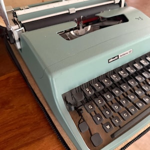 May include: A set of three ceramic mugs with a speckled, matte finish. The mugs are in shades of blue, green, and white. Each mug has a simple, modern design and a comfortable handle. Ideal for coffee or tea.