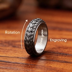 May include: A silver-colored ring with a textured, scale-like pattern. The ring has the engraved words "love you" on the inside. The image shows the ring's rotation and engraving.