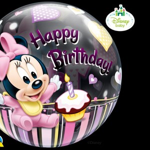 May include: A clear, round balloon featuring a cartoon image of Minnie Mouse in a pink outfit. The balloon has the words "Happy Birthday!" and heart shapes. A cupcake with a lit candle is also visible.