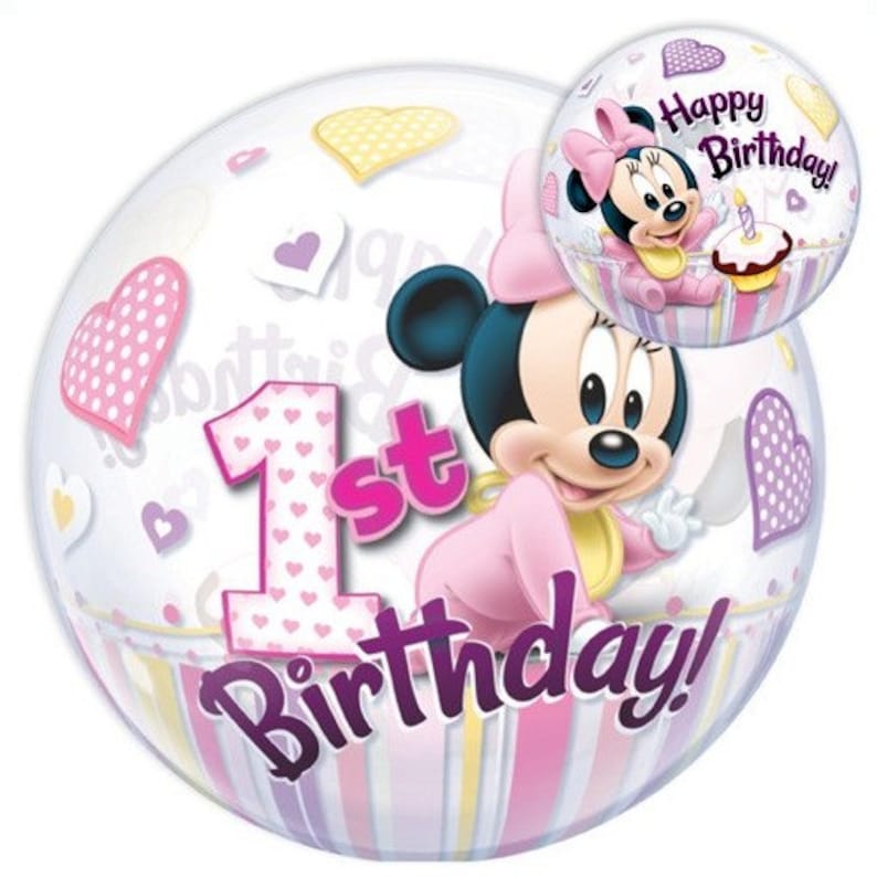 May include: A clear bubble balloon featuring Minnie Mouse in a pink outfit, with the text "1st Birthday!" and "Happy Birthday!". The balloon is decorated with hearts and a striped pattern in pink, purple, and yellow.