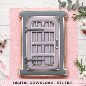 May include: A rectangular cookie shaped like a window with a dark gray frame and a light purple interior featuring a grid pattern. The design includes two dark gray hinges on the left side and a small vertical handle on the right side, all outlined in white icing.